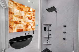 Bathroom featuring plus walk in shower and tile walls