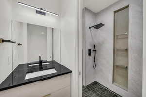 Bathroom with tiled shower and vanity