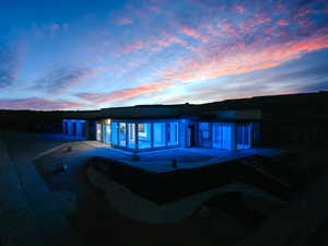 Back house at dusk featuring a patio