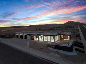 Back house at dusk with a mountain view and a patio area