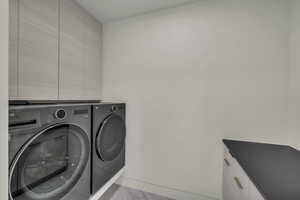 Laundry room featuring cabinets and washing machine and dryer