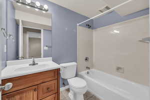 Full bathroom featuring shower / bath combination, vanity, tile patterned floors, and toilet