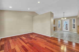 Interior space featuring an inviting chandelier, hardwood / wood-style floors, and lofted ceiling