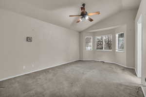 Spare room with ceiling fan, lofted ceiling, and carpet floors