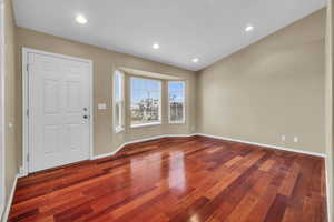 Entryway featuring wood-type flooring and vaulted ceiling