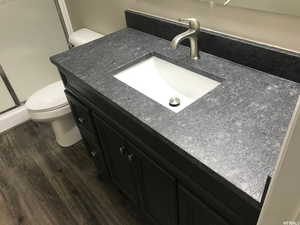 Bathroom featuring wood-type flooring, toilet, and vanity