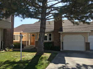 View of front of house featuring a garage and a front yard