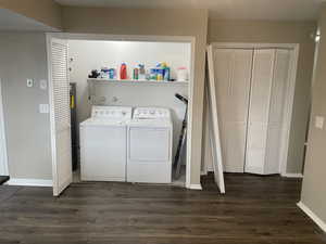 Washroom with separate washer and dryer and dark hardwood / wood-style floors