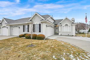 Ranch-style house featuring a garage and a front lawn