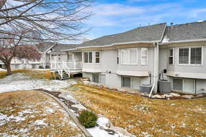 Snow covered house featuring a yard and central AC unit