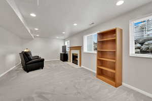 Living area with light colored carpet and a textured ceiling