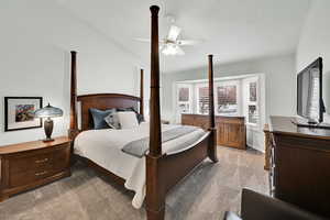 Bedroom featuring vaulted ceiling, light colored carpet, and ceiling fan