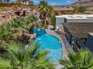 View of pool with a patio, a mountain view, and pool water feature