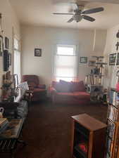 Carpeted living room with ceiling fan