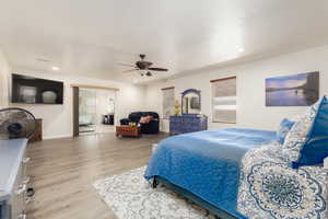 Bedroom featuring ceiling fan, a textured ceiling, and light wood-type flooring