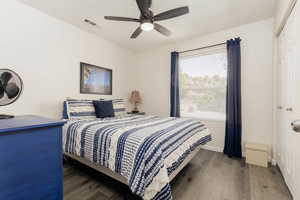 Bedroom featuring dark hardwood / wood-style flooring, a closet, and ceiling fan