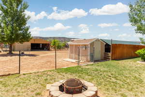 View of yard featuring an outbuilding and an outdoor fire pit