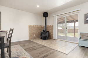 Unfurnished living room with wood-type flooring, a textured ceiling, and a wood stove