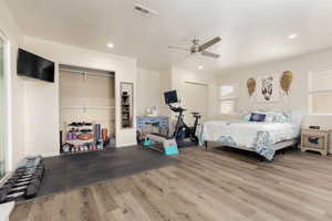 Bedroom featuring hardwood / wood-style flooring, ceiling fan, and a textured ceiling