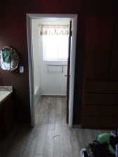 Bathroom featuring wood-type flooring, vanity, and a tub