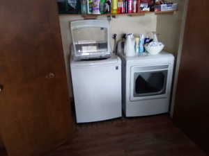 Laundry area featuring dark hardwood / wood-style flooring and washing machine and clothes dryer