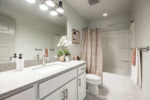 Full bathroom with vanity, toilet, and shower / bath combo with shower curtain