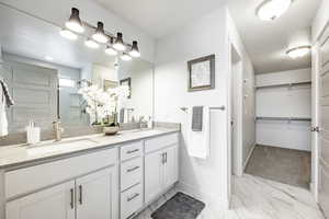 Bathroom featuring an enclosed shower, vanity, and a textured ceiling