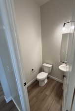 Bathroom with hardwood / wood-style floors and toilet