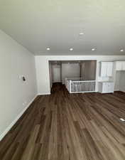 Unfurnished room with dark hardwood / wood-style flooring and a textured ceiling