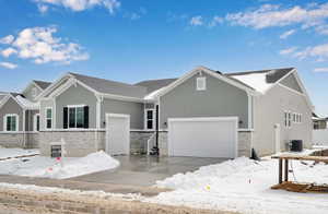 View of front facade with a garage and central AC unit