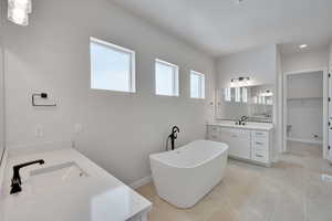 Bathroom with vanity, tile patterned flooring, and a bathing tub