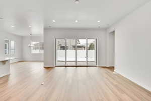 Spare room featuring a notable chandelier and light hardwood / wood-style floors