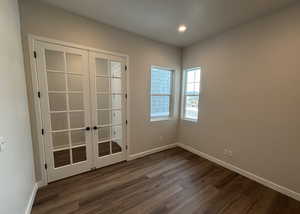 Unfurnished room with french doors and dark hardwood / wood-style flooring