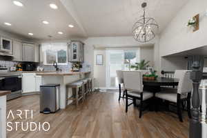 Kitchen featuring tasteful backsplash, pendant lighting, light stone counters, and electric stove