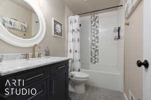 Full bathroom with shower / tub combo with curtain, vanity, and toilet