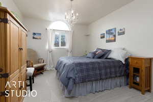 Carpeted bedroom with a notable chandelier