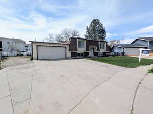 View of front of house with mansard roof, an attached garage, concrete driveway, a front lawn, and roof with shingles