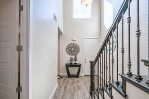 Foyer entrance featuring a towering ceiling and light hardwood / wood-style flooring