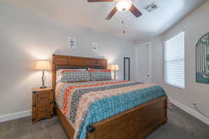 Carpeted bedroom featuring ceiling fan