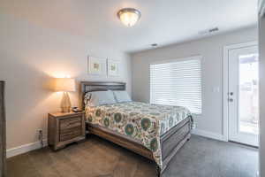 Bedroom featuring multiple windows and dark carpet