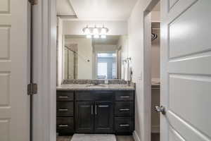 Bathroom with vanity and a shower with door