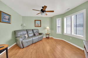 Living room featuring ceiling fan, light hardwood / wood-style floors, and a textured ceiling