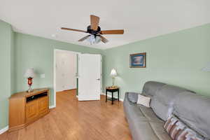 Living room with ceiling fan, light hardwood / wood-style floors, and a textured ceiling