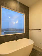 Bathroom featuring a tub to relax in and tile patterned flooring