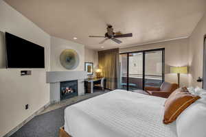 Carpeted bedroom featuring ceiling fan and access to outside