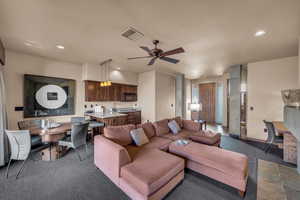 Living room featuring ceiling fan and sink