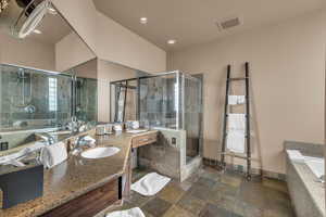 Bathroom featuring vanity and shower with separate bathtub