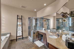 Bathroom featuring shower with separate bathtub and vanity