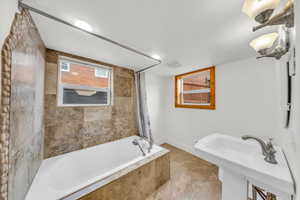 Bathroom with tile patterned floors, sink, and shower / bath combo with shower curtain