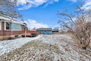 Yard covered in snow featuring a wooden deck